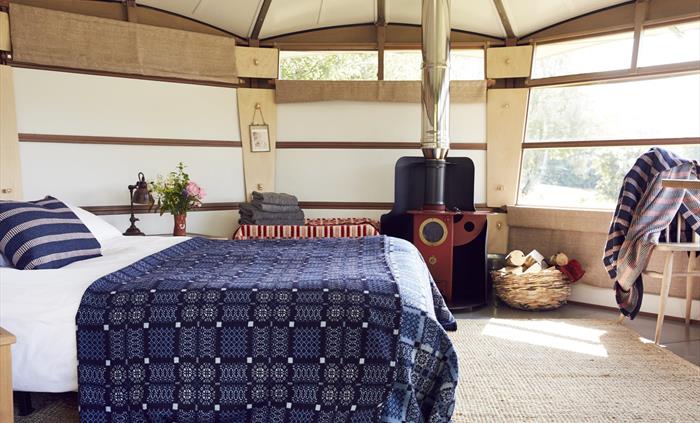 Cwtch up beside our Chilli Penguin Wood Burning Stove, sleep in a double bed with cotton sheets, electric blanket, duvet and Melin Tregwent’s wonderfu